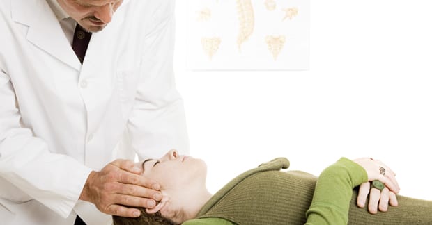 Chiropractor taking care of women with headache
