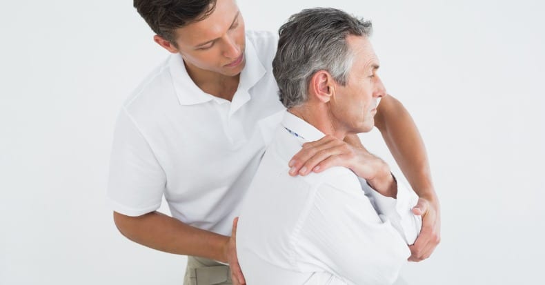 Male chiropractor examining mature man