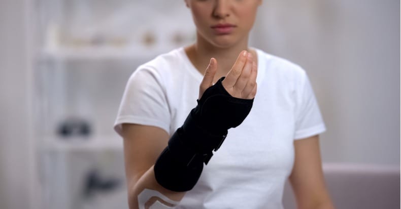 Female checking titan wrist brace rehabilitation after sports trauma