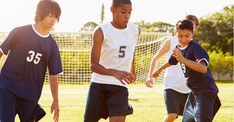 Members of male high school soccer playing match