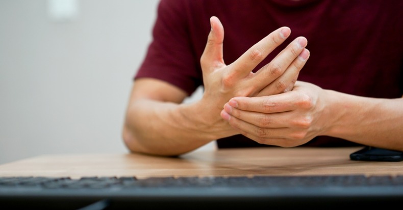 Close up freelancer man use hand to massage for relief pain from hard