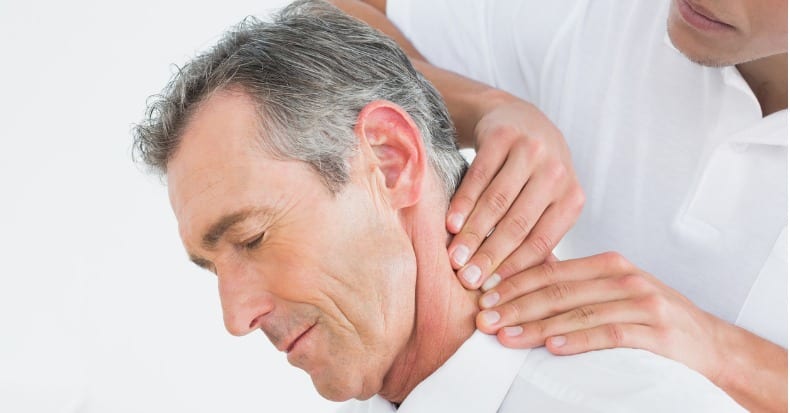 Male chiropractor massaging patients neck