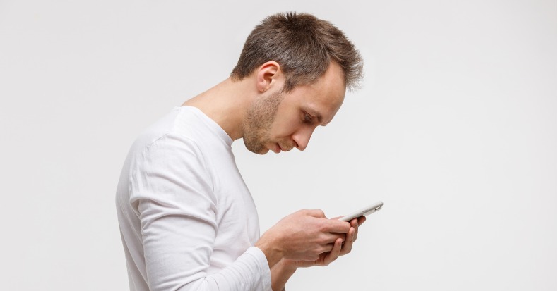 Man looking and using smart phone with scoliosis incorrect posture