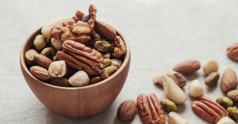 Mixed nuts in wooden bowl healthy fat and protein food and snack