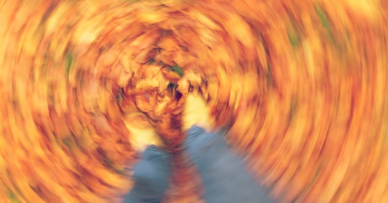 Motion blurred photograph of man or womans feet walking through fall