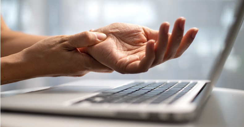 Woman massaging painful wrist at work repetitive strain injury