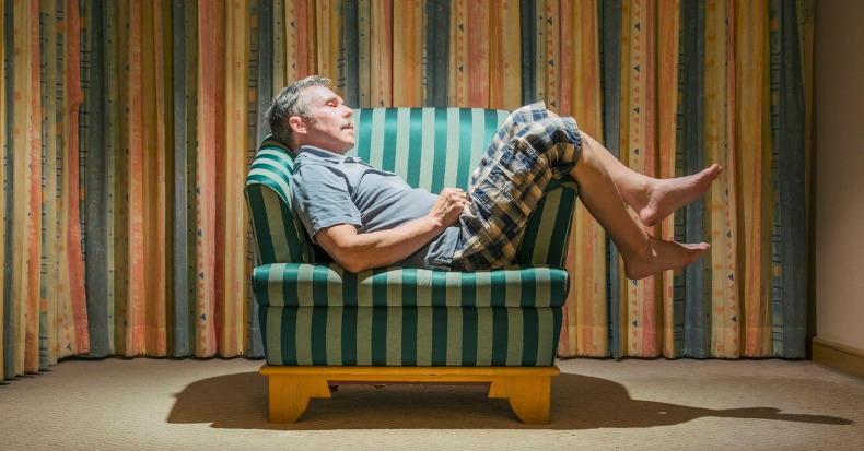 An elderly tourist dozed off in a chair in an inexpensive hotel